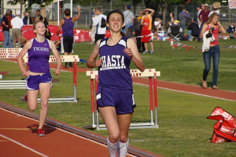 Shasta's Lora James, rebuffing challenges by Lassen's Tiffany Hefflin early and Oroville's Sarah Brandt (background) late, to come through with the victory in the girls 1600m. She also place second in the 800m and anchored the Wolves winning effor in the 4 X 400 relay.(TC)
