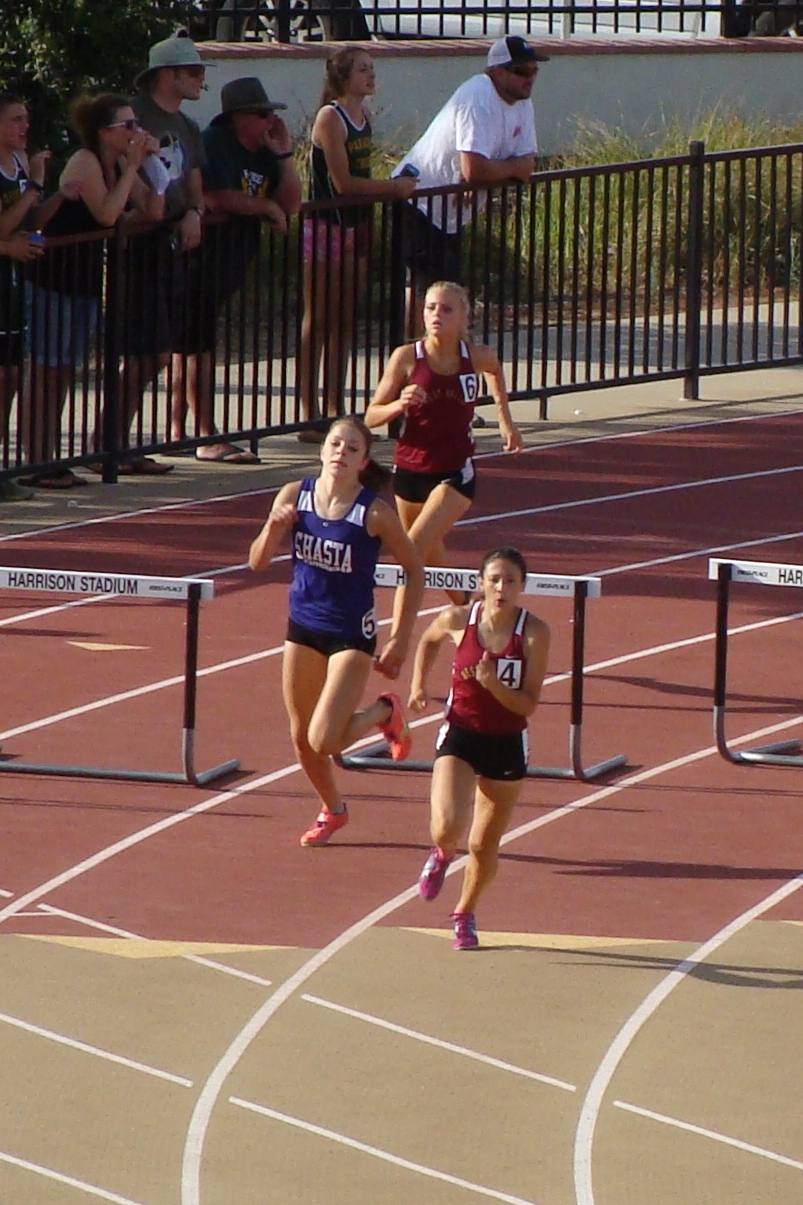 Two of the section's top hurdles West Valley's Kristina Freitas and Shasta's Molly Ross with a 100m to go in the varsity girls 300 hurdles with Eagle's Samantha Chaney a distant third. (TC)
