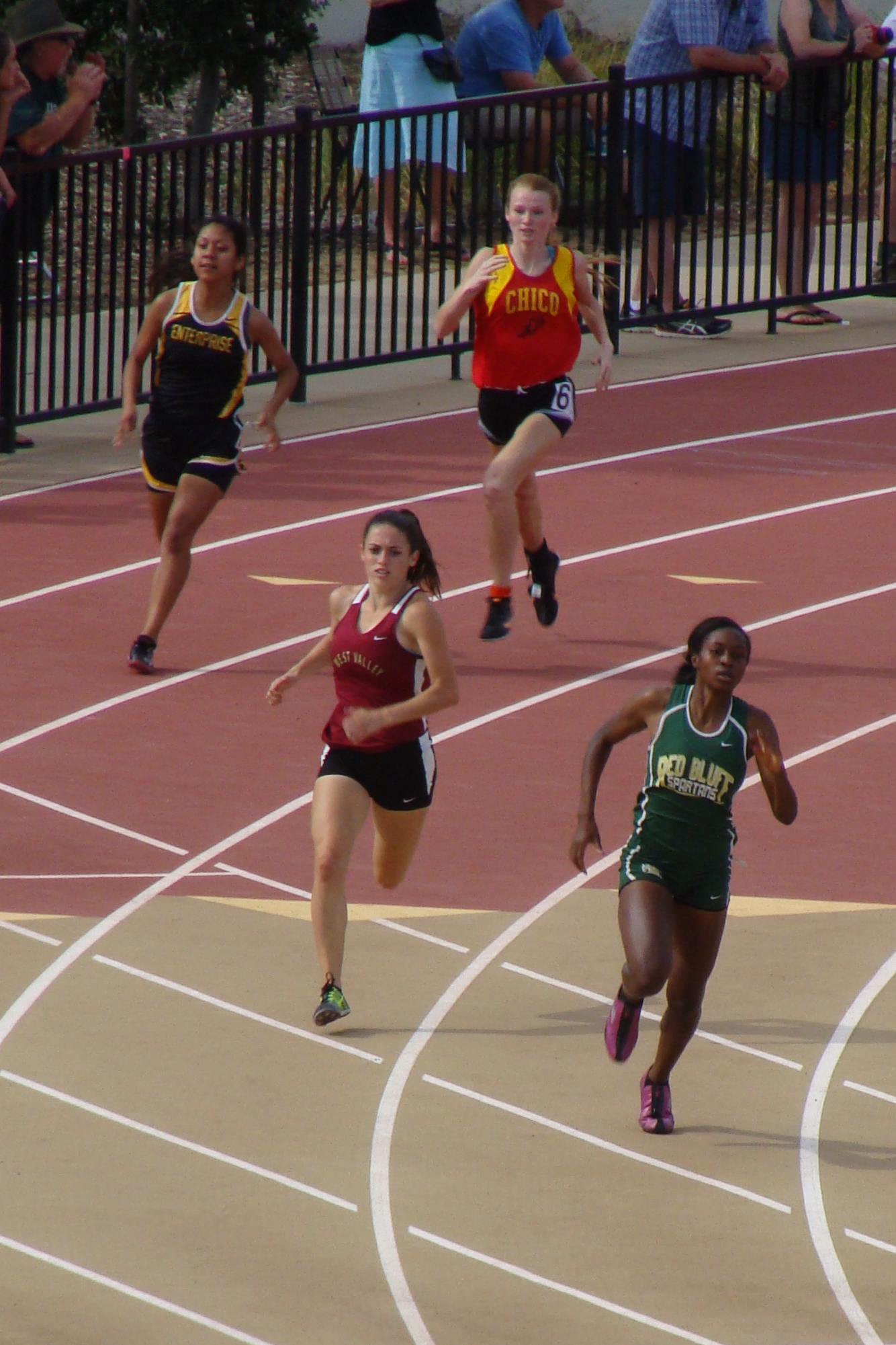 Red Bluff's Adrienne Hinkston rounding the final turn firmly in the lead over West Valley's Alexa Flagg. Chico's Sharlotte Sheffield and Enterprise's Patricia Dionicio are see trailing behind. (TC)