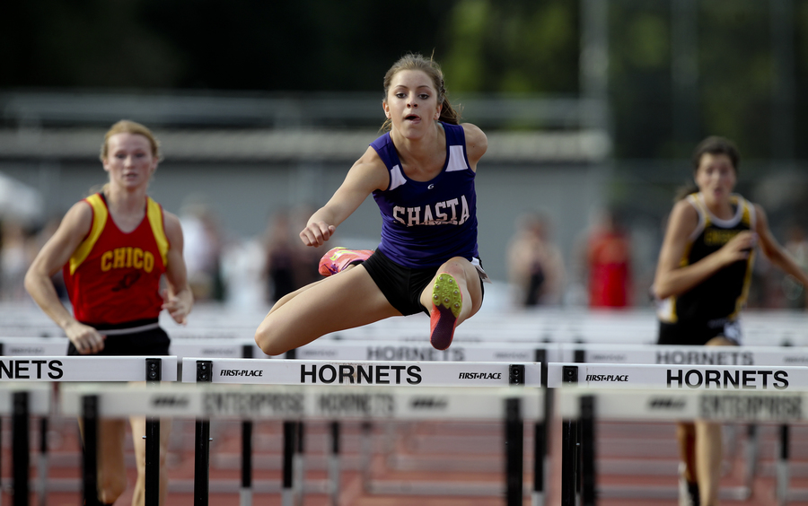 Shasta's Molly Ross, unlike the week before, has no problem dispatching Chico's Sharlotte Sheffield to win the varsity girls 100m hurdles. (RS)