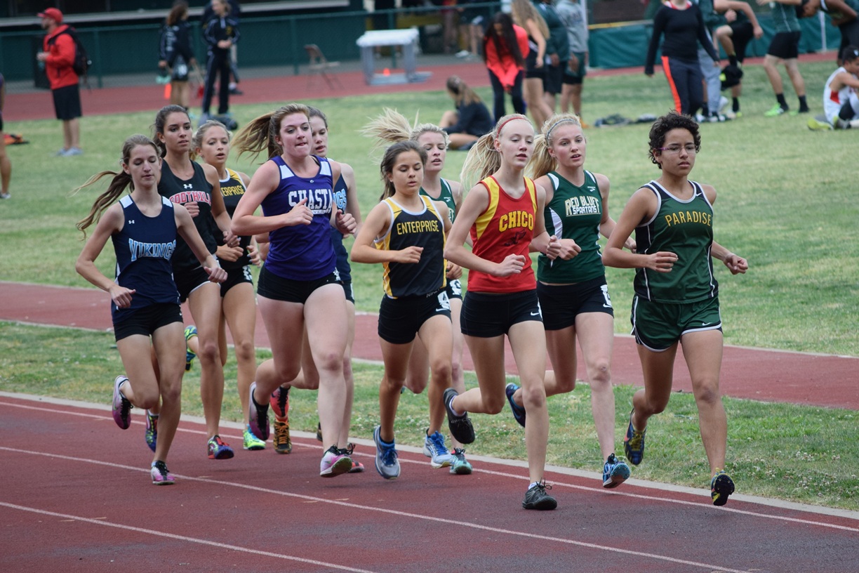 The field in the varsity girls 3200m is tightly bunched after the opening lap. Enterprise's Natalie Ulloa(middle of the pack) would take control of the race a lap later and pull away for an easy win. The winner of the 1600m Shasta's Hannah Davis is on her right shoulder.