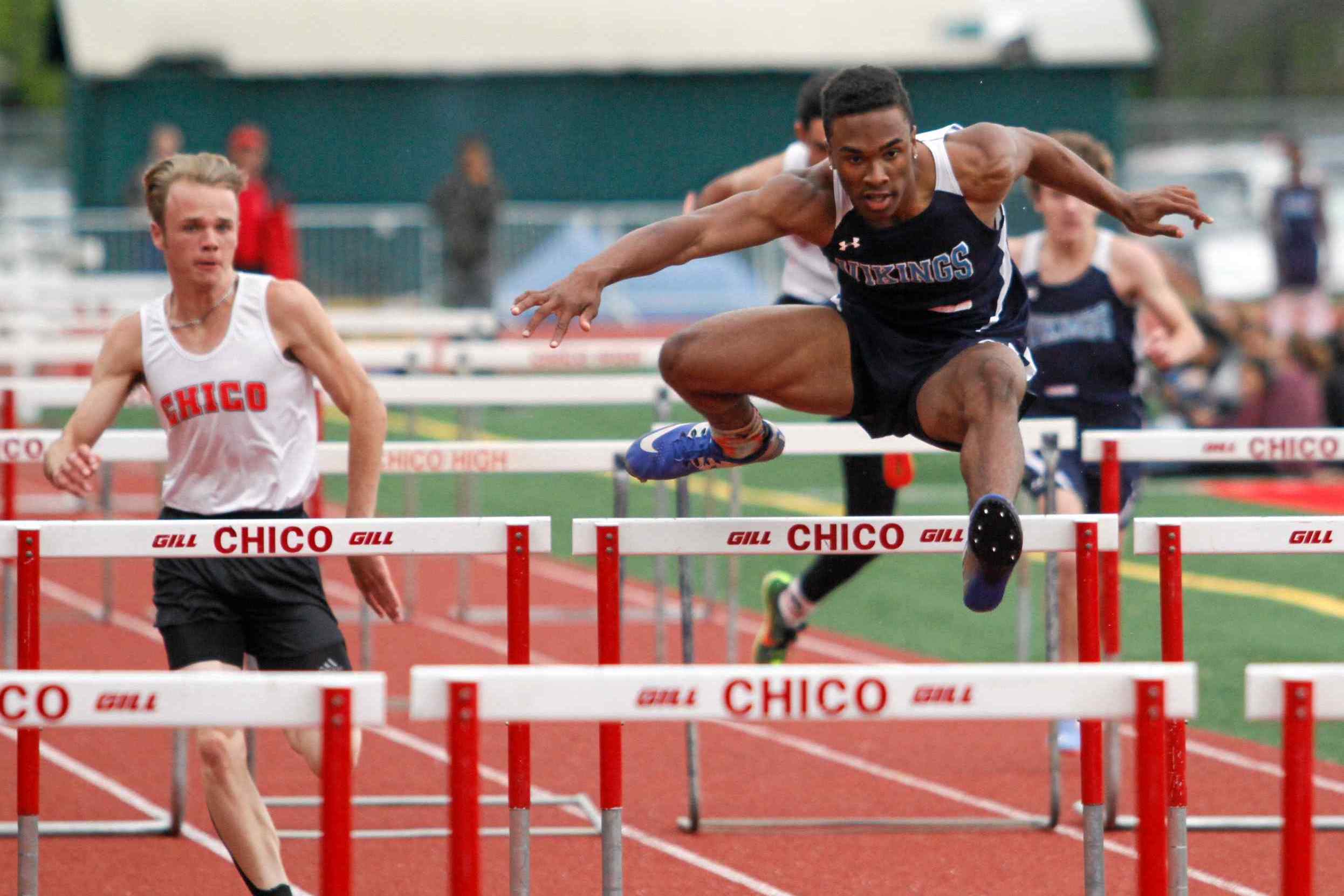 Pleasant Valley's Jamarquez Abrams leaps over a hurdle and wins the 110-meter hurdles with Chico High's Trevor Trento, left, coming in second Wednesday at Chico High.