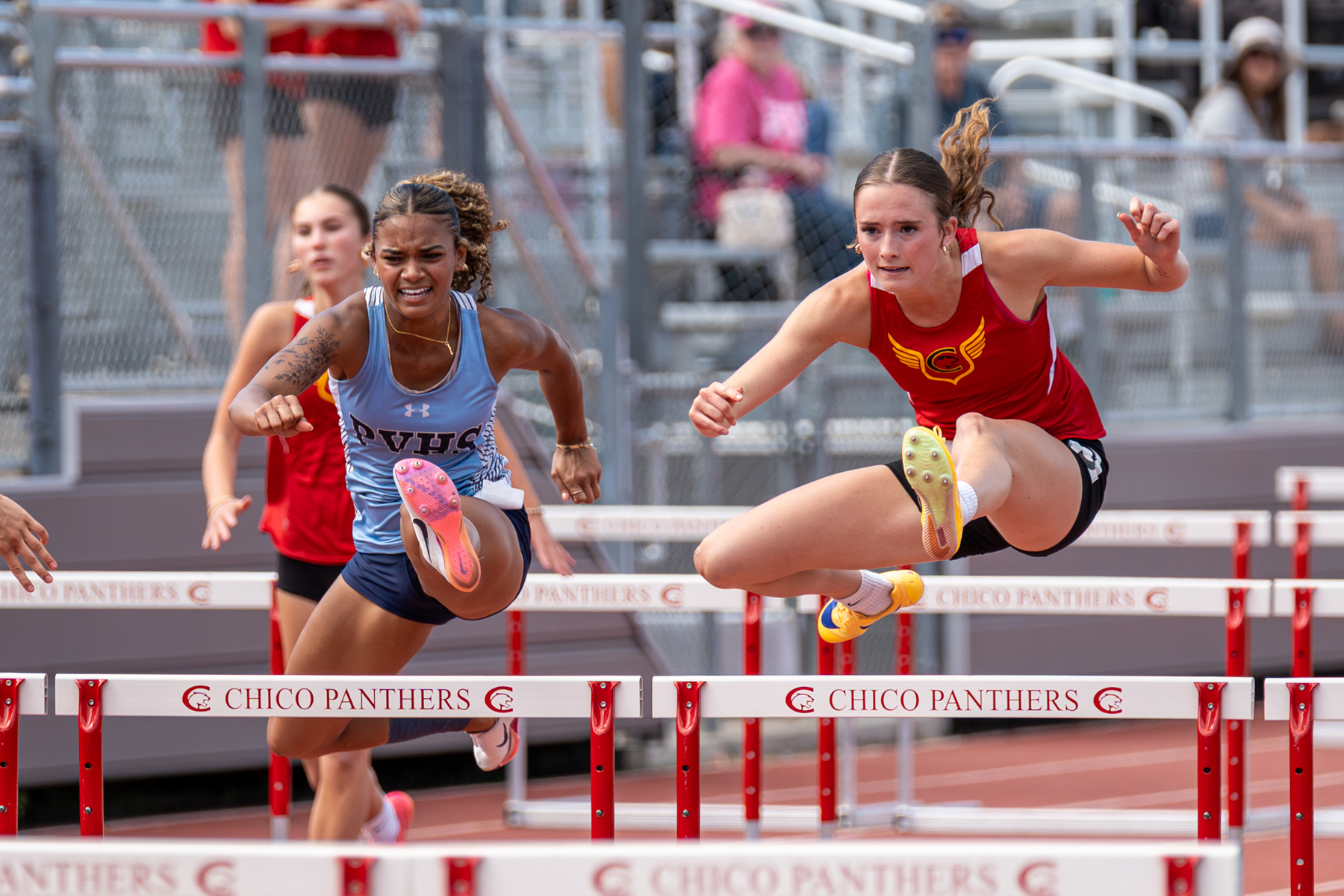 Pleasant Valley's Amarianna Sims, left, and Chico's Grace Puterbaugh, right, compete in the hurdles on Wednesday, April 8, 2026 at Panther Stadium in Chico, California. (Ben Mota/All Axis Sports)